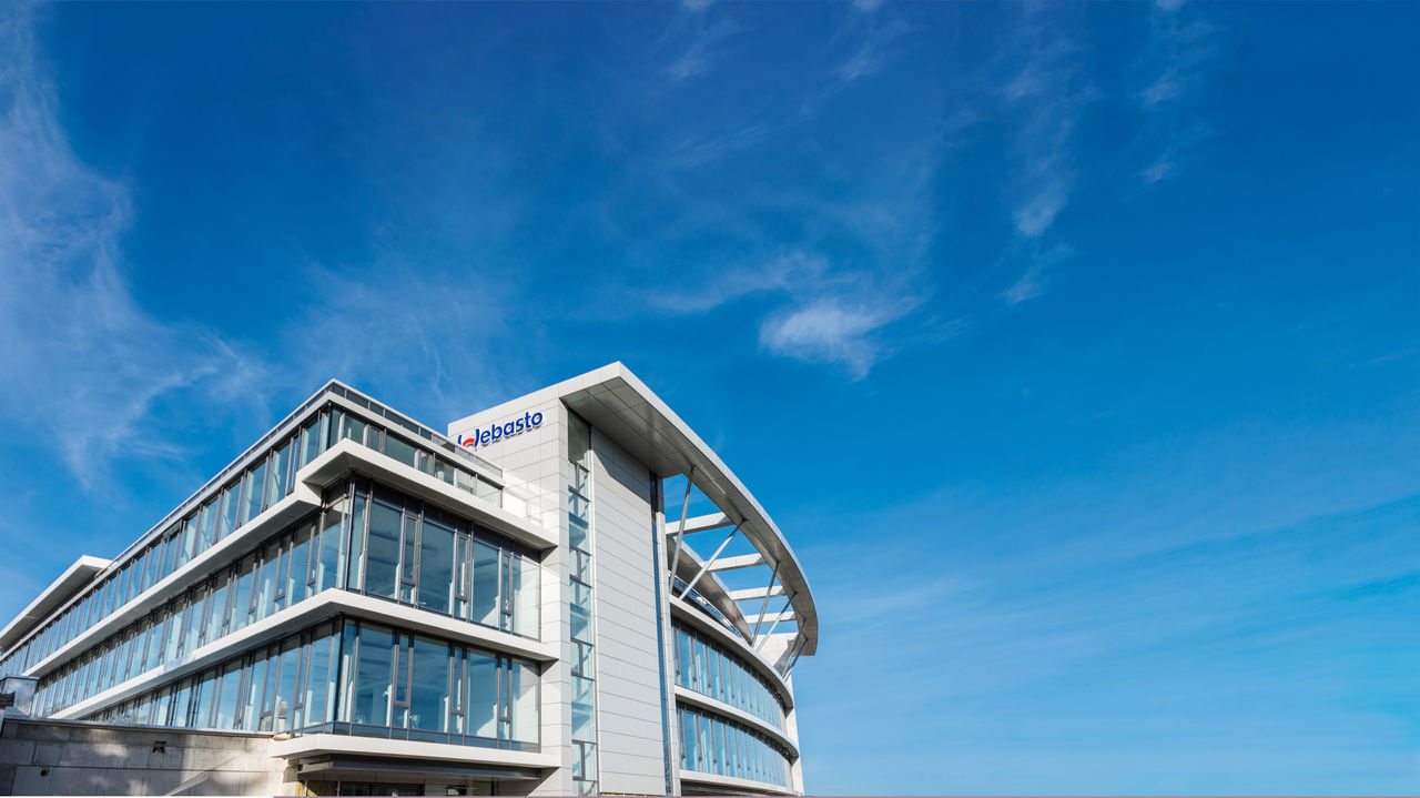 Webasto headquarter with logo against blue sky, reinforcing the Group’s global systems partner identity